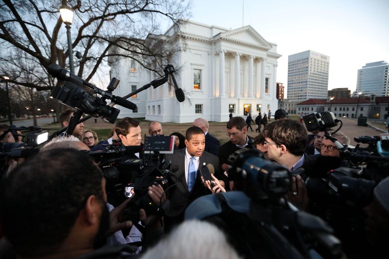 Virginia Lieutenant Governor Justin Fairfax stands in the middle of a scrum of reporters with cameras and mics outside the Virginia capital building.